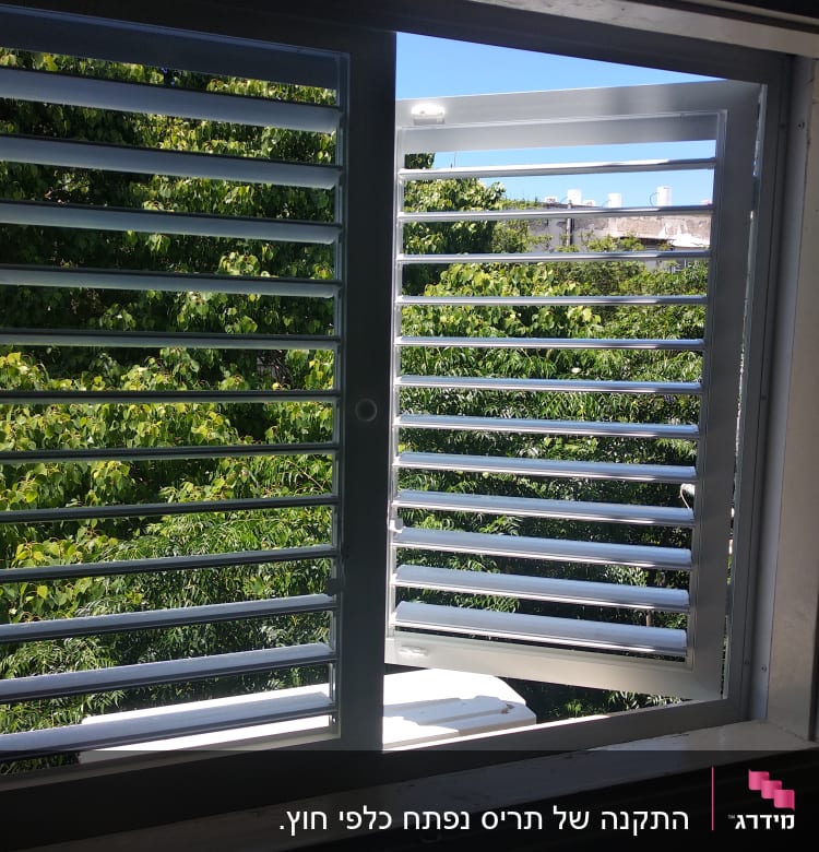 תריסי אלומיניום פתוחים בחלון